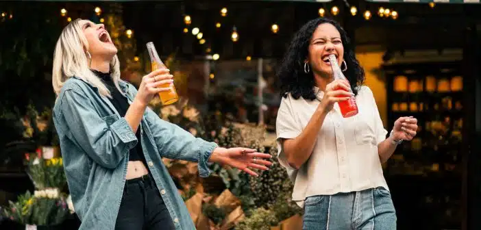 man in blue denim jacket holding clear drinking glass