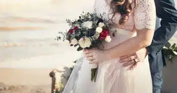 man standing in front of woman holding bouquet of flowers