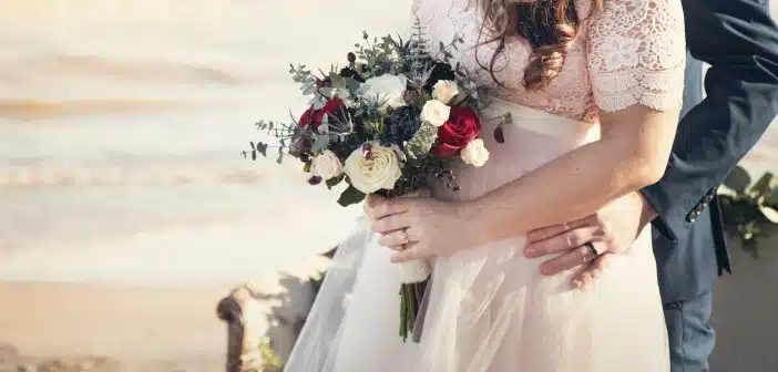 man standing in front of woman holding bouquet of flowers