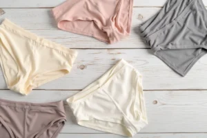 Comparaison de matières pour kangourou slip sur peau sensible — coton, modal et synthétique en vue à plat